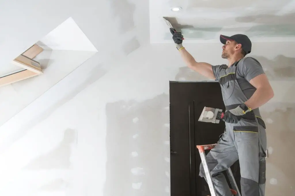 man doing drywalls to show when to glue drywall